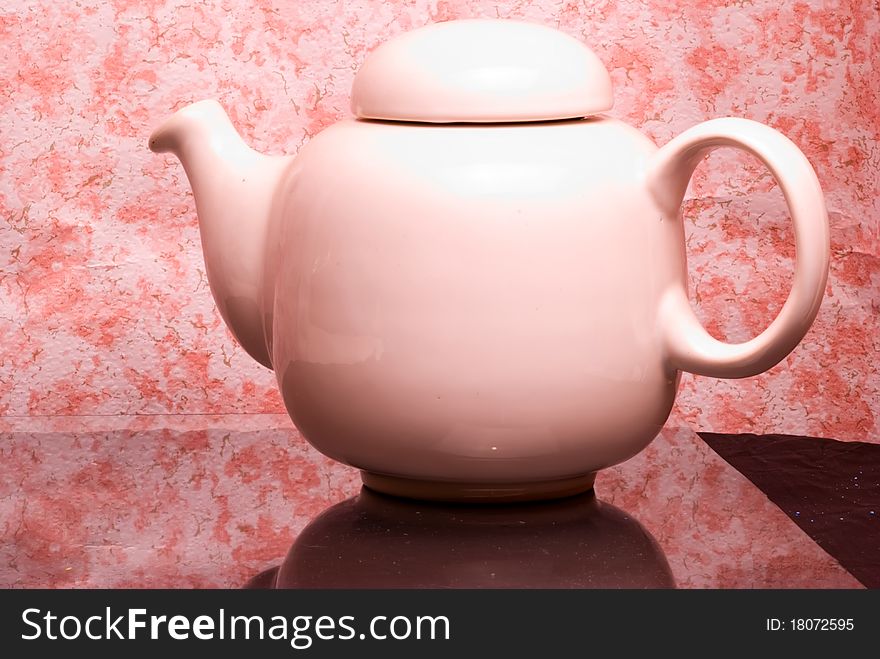 White ceramic teapot on reflexive medium