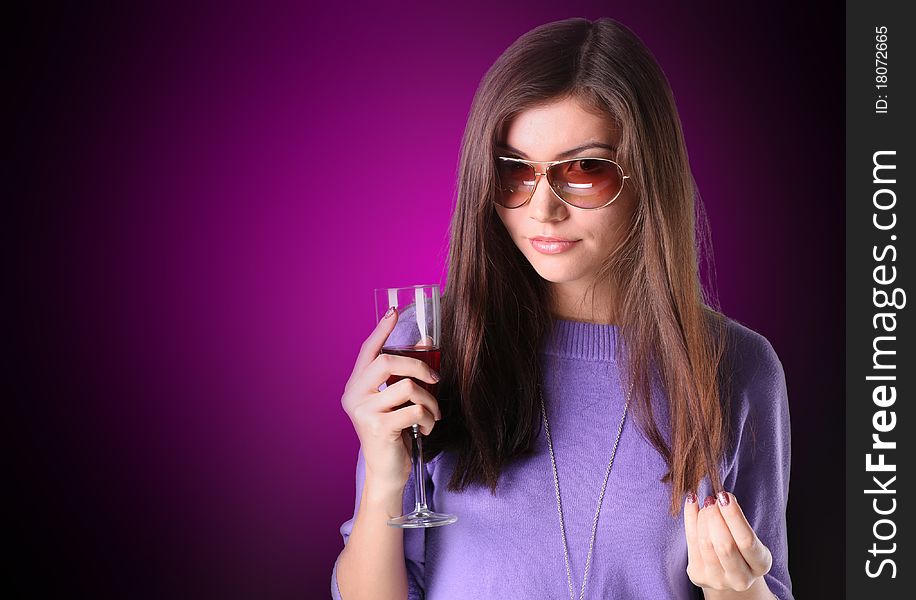 Women on red is holding a glass of white wine. Women on red is holding a glass of white wine