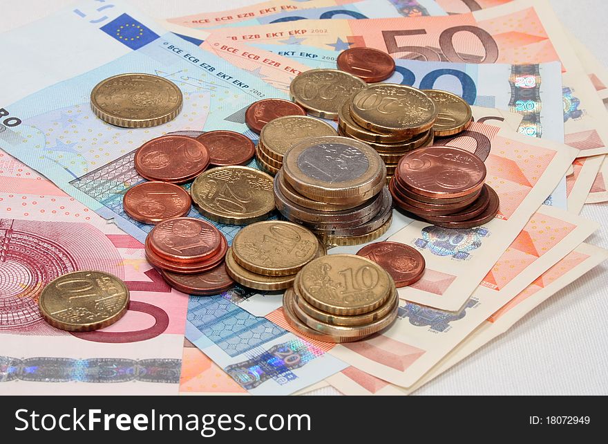 Several euro coins over banknotes. Several euro coins over banknotes