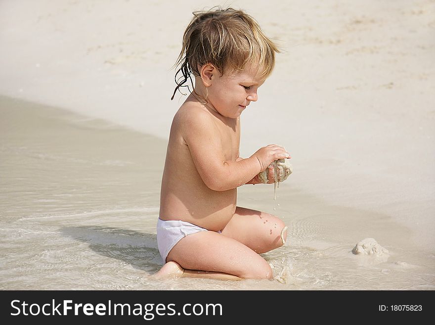 Cute child playing with sand on beach. Cute child playing with sand on beach