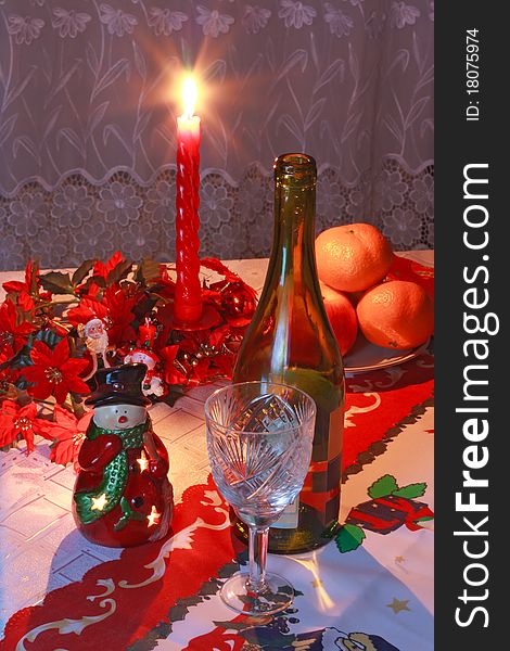 New Year's setting with wine, glass, tangerines, christmas decoration and candle