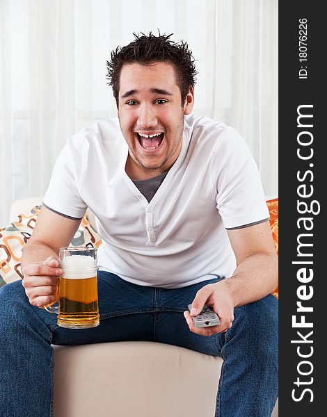 Young boy with a glass of beer and remote control