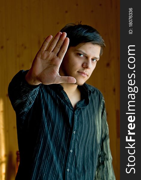 Young man showing a sign stop