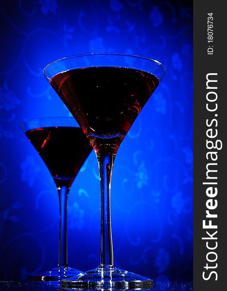 Pair of martini glass on blue abstract background. Pair of martini glass on blue abstract background