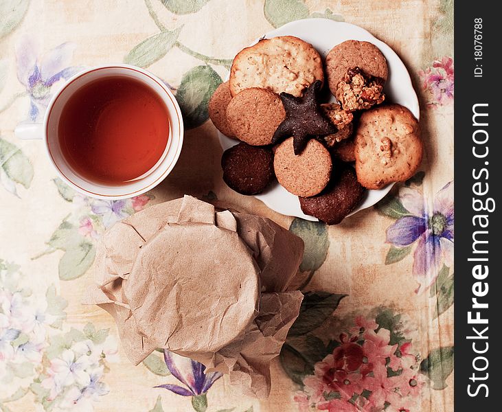 Tea with honey and cookies on flowers pattern, top view