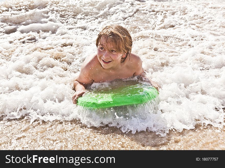 Boy has fun with the surfboard at the beach