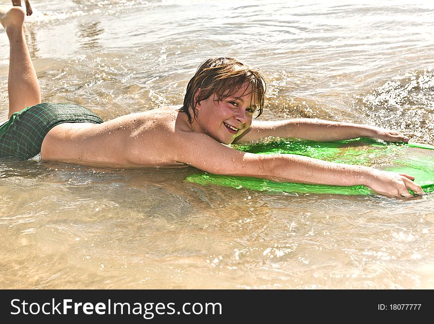 Boy has fun with the surfboard at the beach