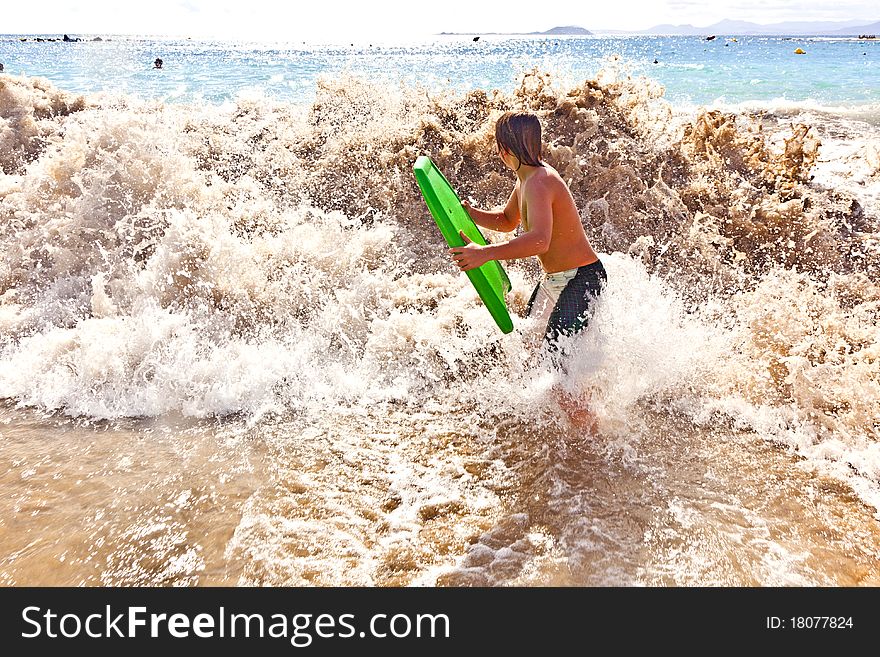 Boy has fun with the surfboard at the beach