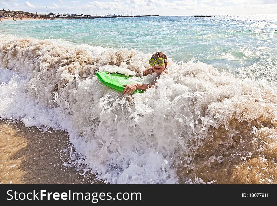 Boy has fun with the surfboard at the beach