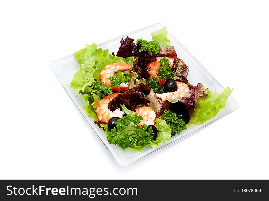 Salad with shrimp, black olives and herbs on a square platter