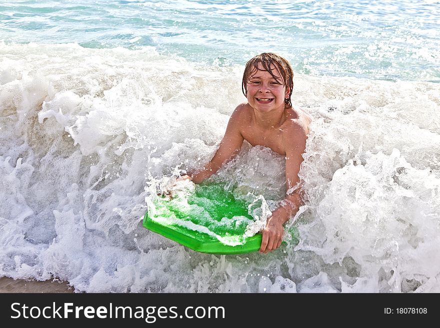 Boy has fun with the surfboard at the beach