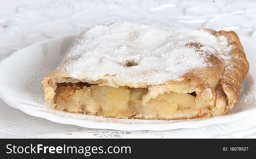 Piece apple strudel on a white plate on a light background. Piece apple strudel on a white plate on a light background