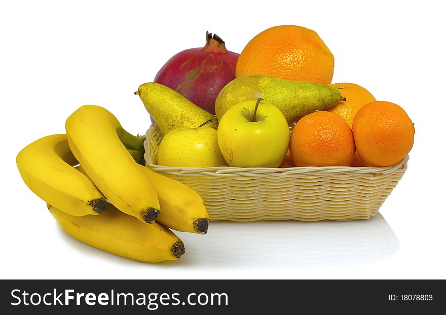 Juicy fruit in a basket on the reflective surface isolated on white background. Juicy fruit in a basket on the reflective surface isolated on white background