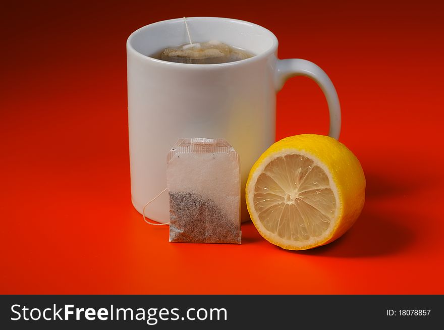 Cup of tea with lemon on a red background. Cup of tea with lemon on a red background