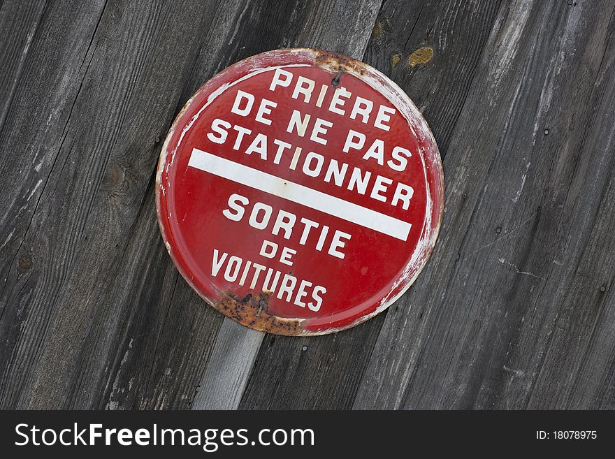 Old rusty forbidden parking sign isolated on wooden plank