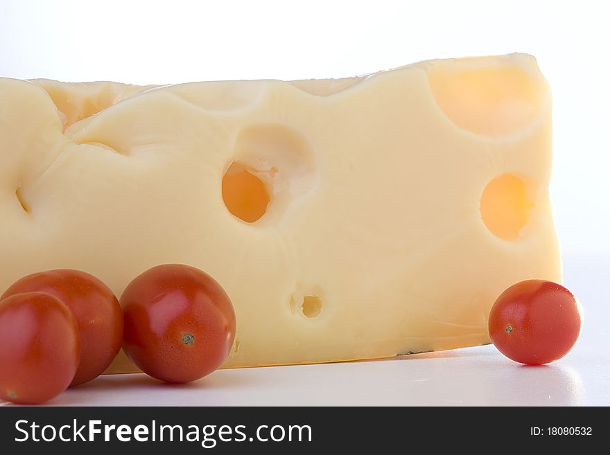Swiss cheese slice with tomato on a white background. Swiss cheese slice with tomato on a white background.