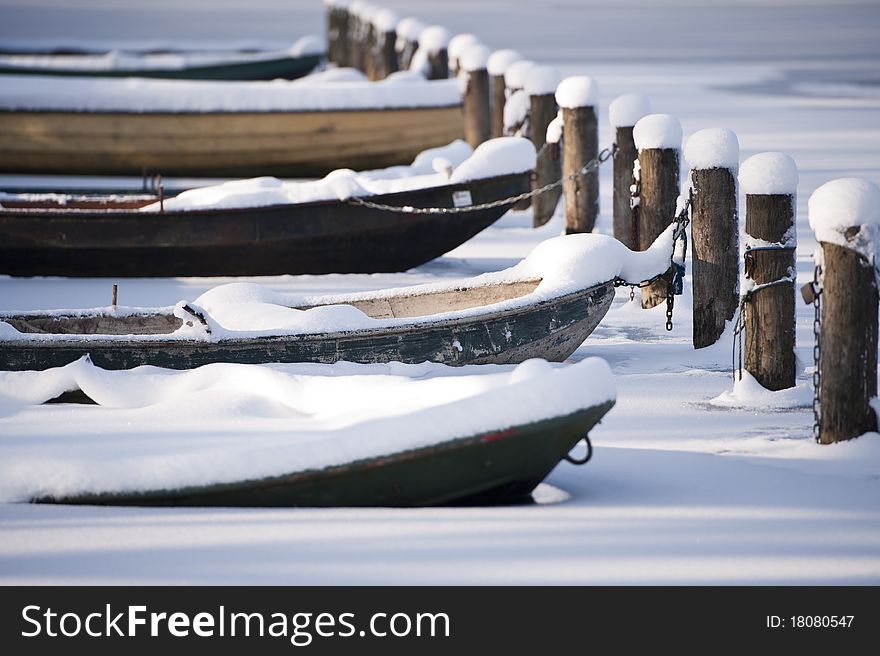A line of rowboats in a frozen lake. A line of rowboats in a frozen lake.