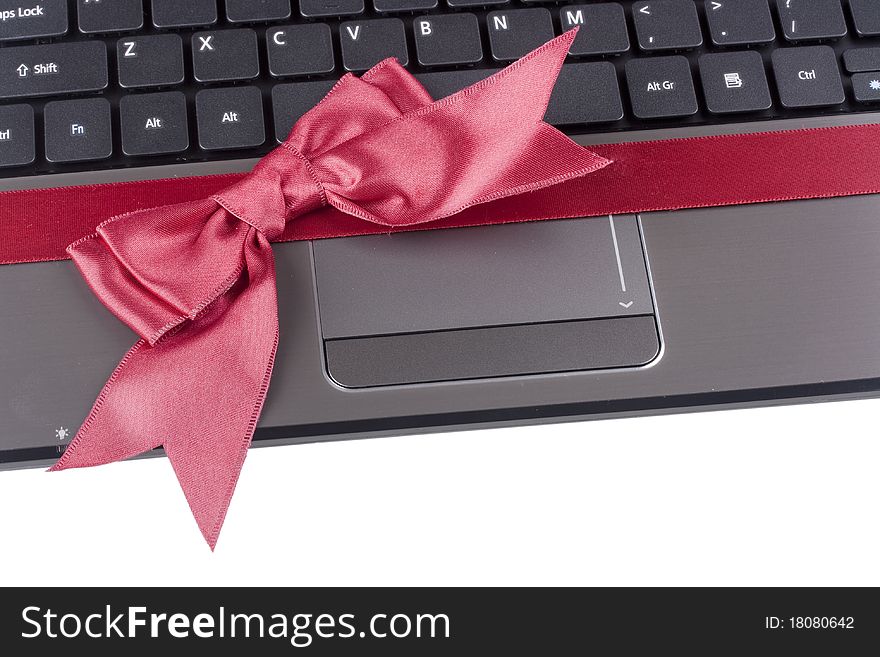 Personal computer as a gift tied with a red ribbon with a bow. Personal computer as a gift tied with a red ribbon with a bow.