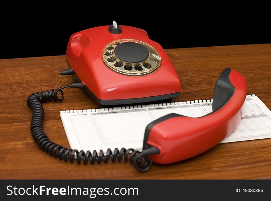 Red phone on a wooden table