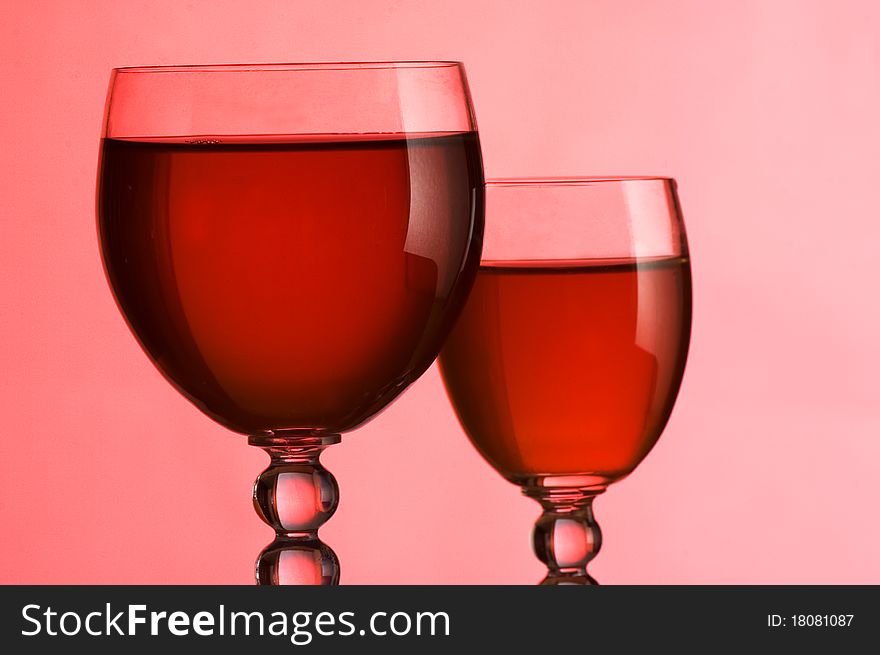Wine glasses with wine on a pink