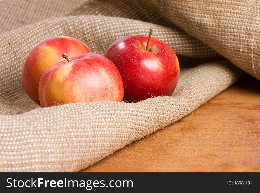 Apples on a sacking on a wooden table still life