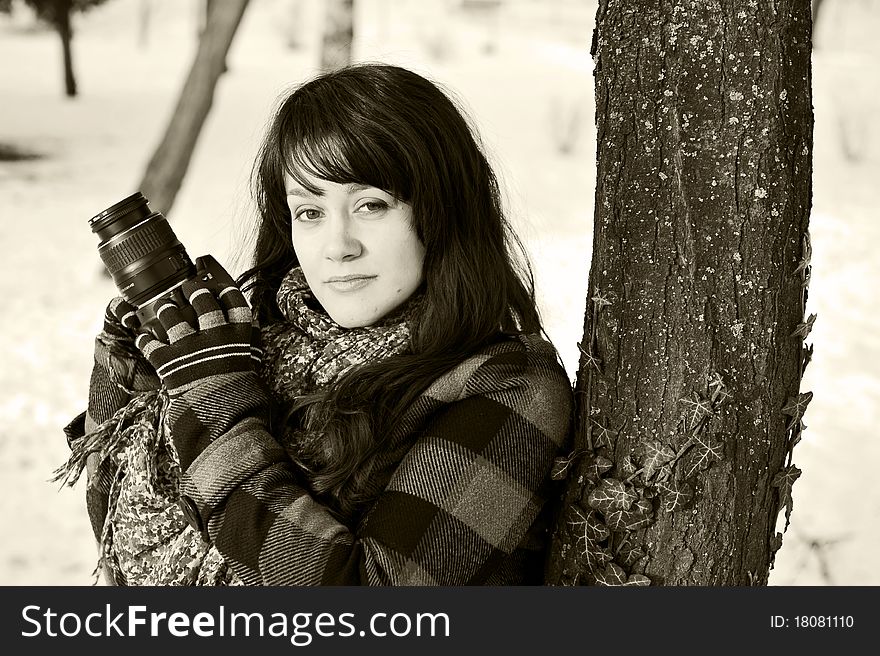 Beautiful woman photographer in winter forest