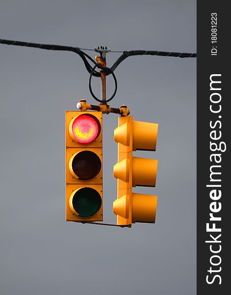 Red traffic light with overcast sky background