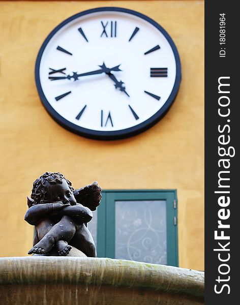 Statue of little cupid sitting under the clock. Statue of little cupid sitting under the clock