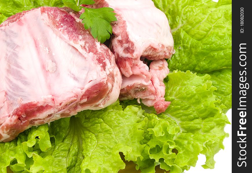 Several damp pigs of the bones with meat are found on sheet of the green salad. Several damp pigs of the bones with meat are found on sheet of the green salad