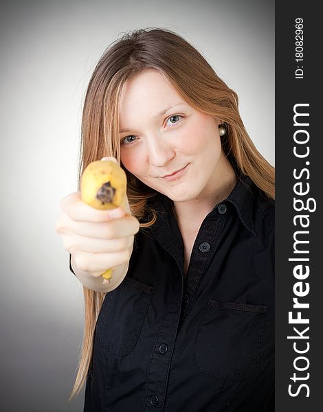 Image of girl holds banana as a gun