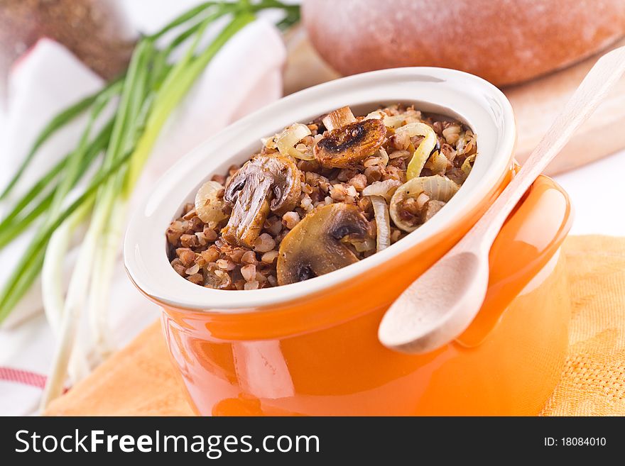 Buckwheat with mushrooms in an orange pot. Buckwheat with mushrooms in an orange pot