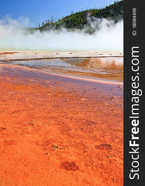 Bright orange and red colors surround the Grand Prismatic hot spring in Yellowstone National Park. Bright orange and red colors surround the Grand Prismatic hot spring in Yellowstone National Park.