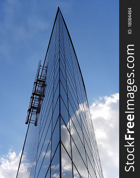 Glass building that looks like the clouds pass through it. Glass building that looks like the clouds pass through it