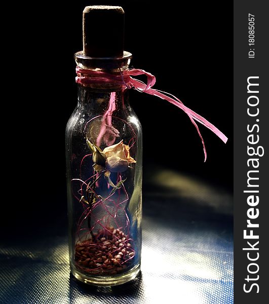 Dried yellow rose in the bottle isolated on black