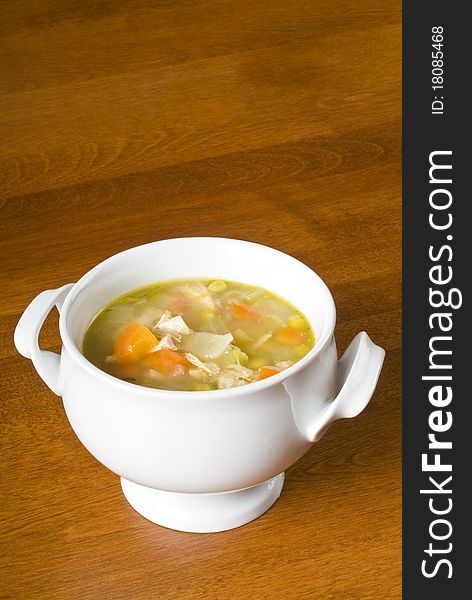 White porcelain bowl of chicken soup with veggies. White porcelain bowl of chicken soup with veggies.