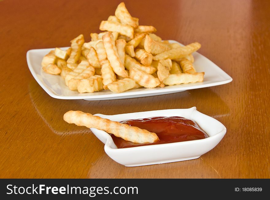 Single French Fry With Ketchup And  Plate Of Fries