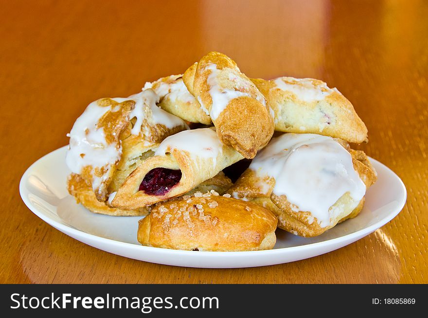 White plate of assorted pastry on old, wooden table. White plate of assorted pastry on old, wooden table