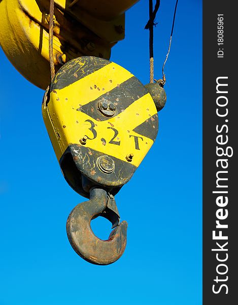 Hook of the elevating crane against the blue sky. Hook of the elevating crane against the blue sky