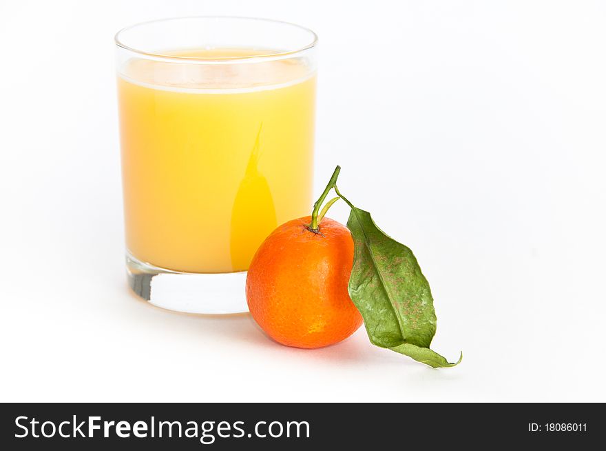 Glass of freshly squeezed orange juice and a single orange fruit with a leaf on isolating background. Glass of freshly squeezed orange juice and a single orange fruit with a leaf on isolating background