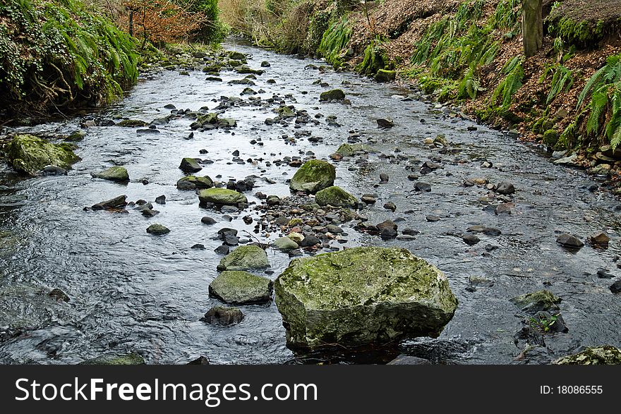 Babbling brook with large rock in the water flow
