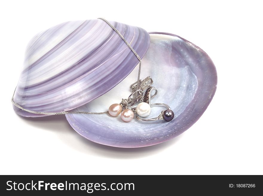 White gold set with pearls on sea shell, isolated on white. White gold set with pearls on sea shell, isolated on white