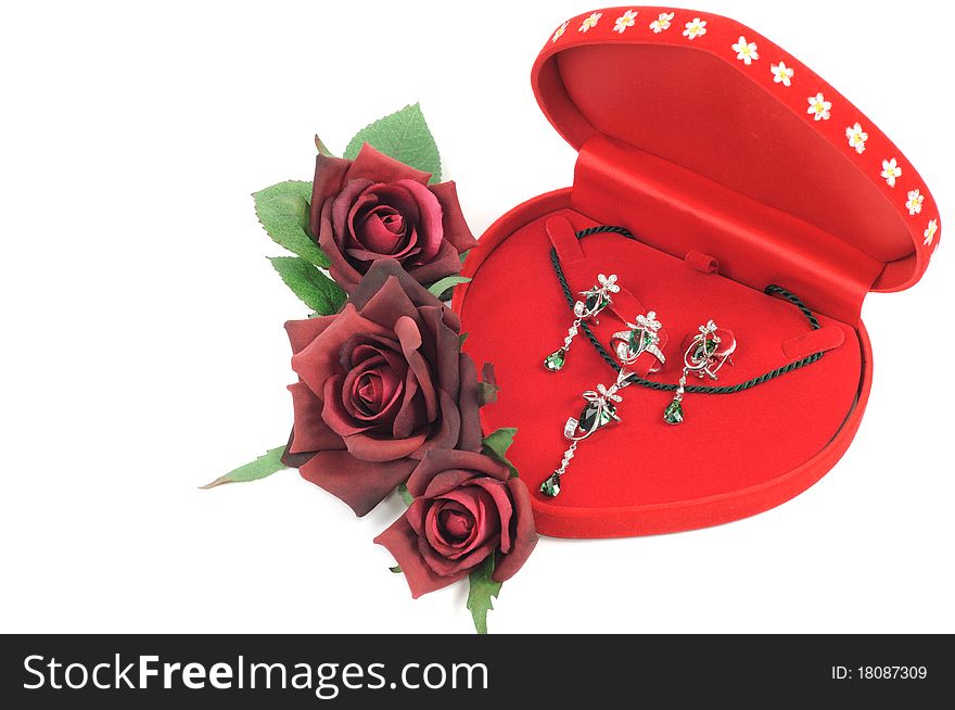 Platinum jewelry set in open red box and roses. Platinum jewelry set in open red box and roses