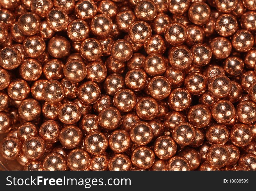 Closeup of a pile of shiny copper BB's.