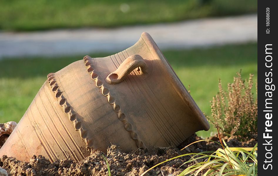 Ancient amphora on green grass in daylight