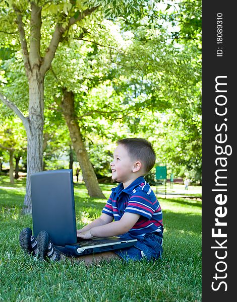 Little boy smiling while playing with laptop. Little boy smiling while playing with laptop