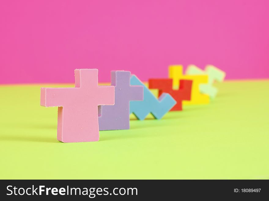 Colorful eraser puzzle pieces in a row with a pink and green background. Colorful eraser puzzle pieces in a row with a pink and green background.