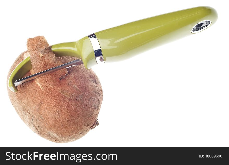 Sweet Potato Being Peeled with Green Vegetable Peeler Isolated on White with a Clipping Path.