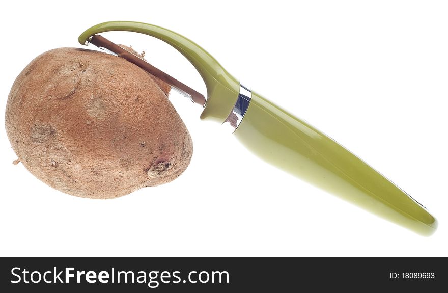 Sweet Potato Being Peeled with Green Vegetable Peeler Isolated on White with a Clipping Path.