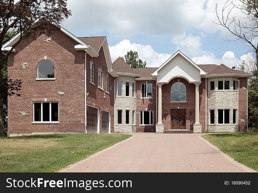 New construction brick home with arched entry