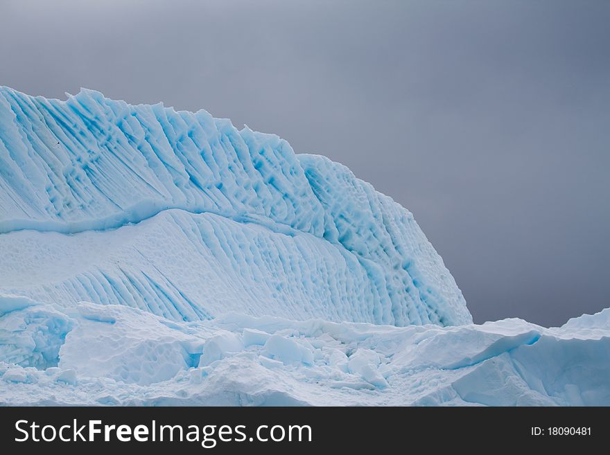 An iceberg is blue in the Antarctic waters. An iceberg is blue in the Antarctic waters